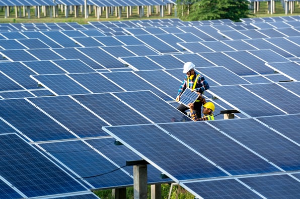 Man stands in solar panel farm
