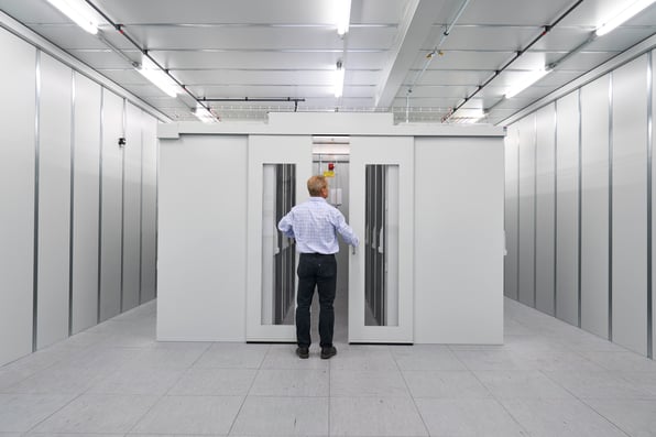 engineer observing an enclosure to show differences between cable management and aisle containment