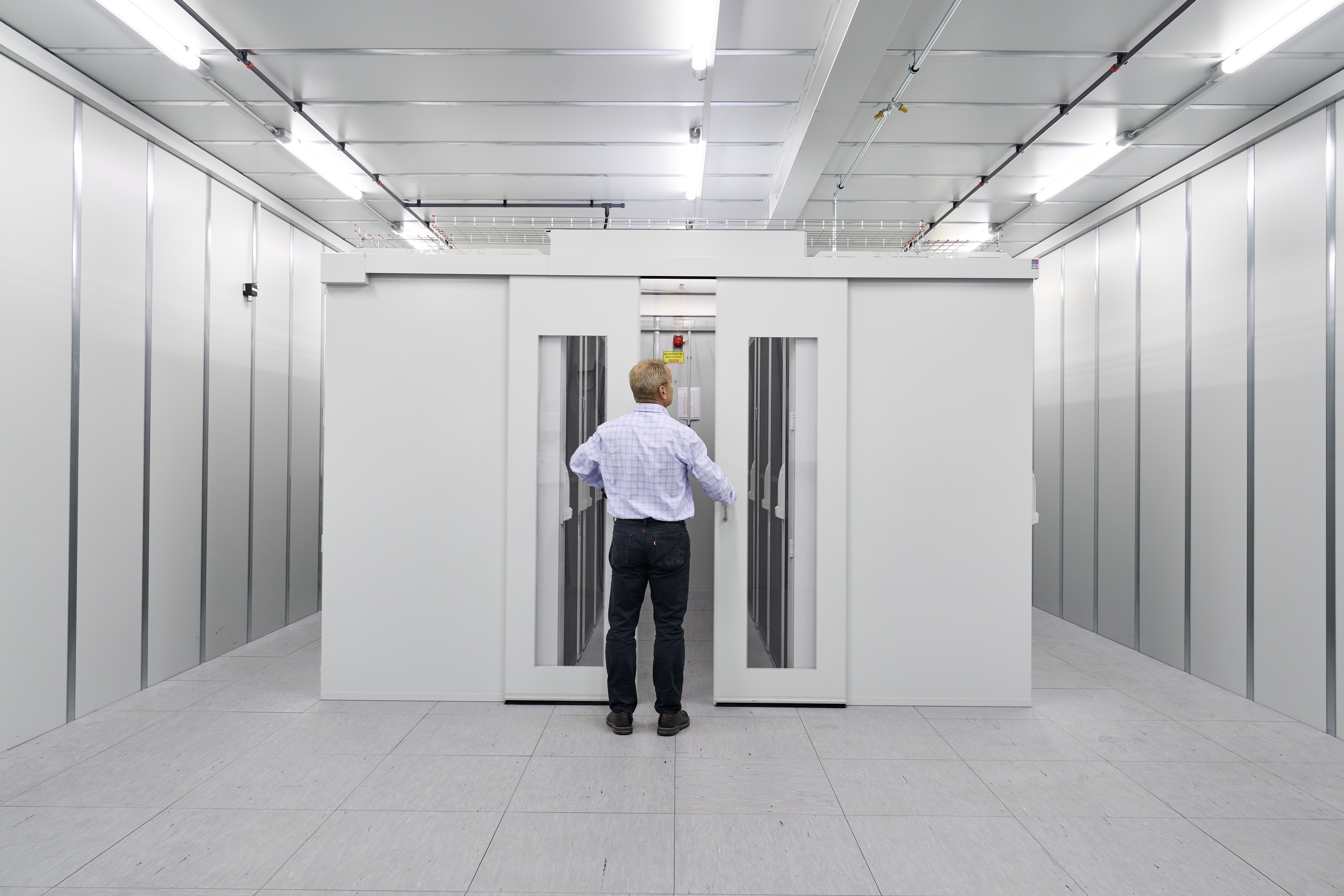 engineer observing an enclosure to show differences between cable management and aisle containment 