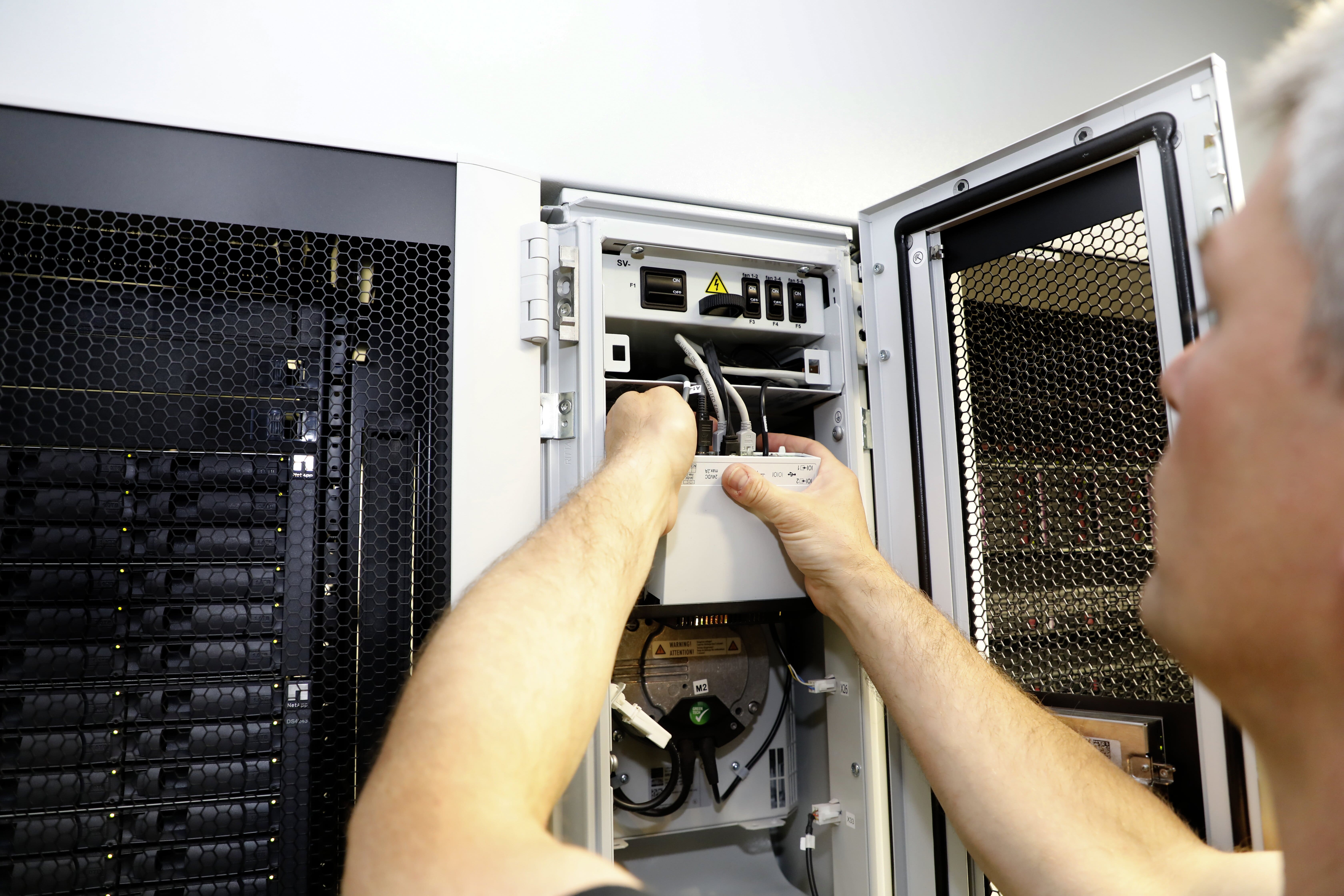 A data centre manager checking equipment that is ready for an upgrade.  